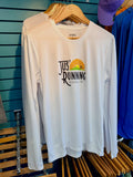 A white long-sleeve athletic t-shirt hanging on a wooden hanger against a teal slatwall. The shirt features a 'Jus' Running Asheville, NC' graphic on the chest with a black logo and a yellow/orange sunburst illustration.